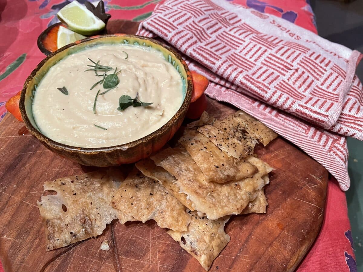 white bean dip and sourdough crackers on a board.