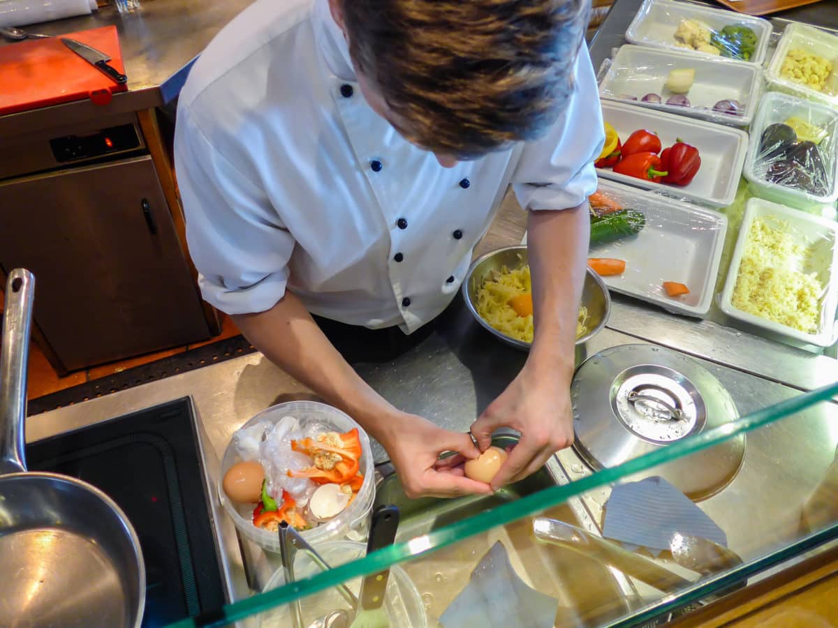 Chef meticulously preparing pankukas in a well-equipped kitchen.