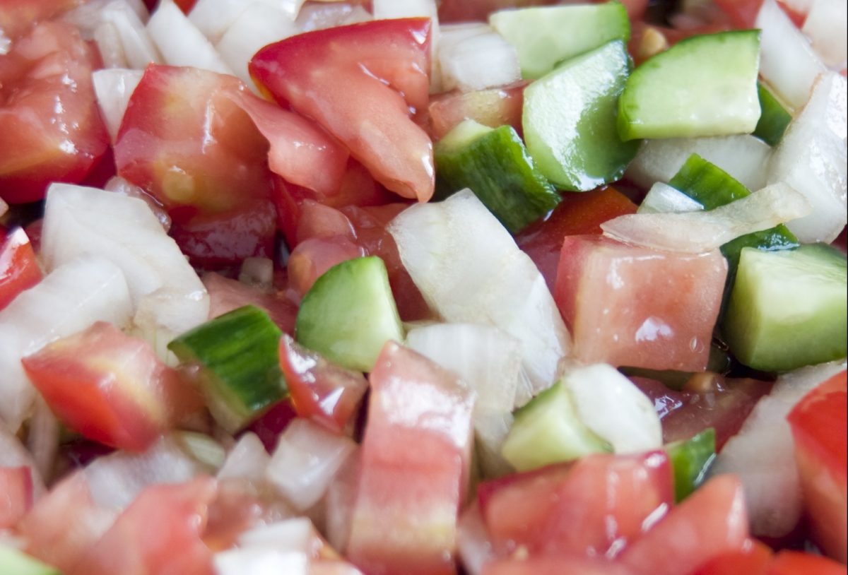 Close-up view of a colorful COban salad with cucumbers, tomatoes, and onions
