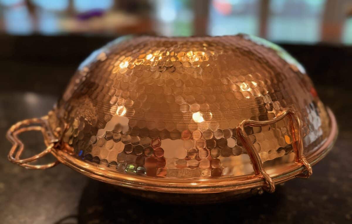 Closed copper cataplana vessel, domed and shaped like a flattened ball.