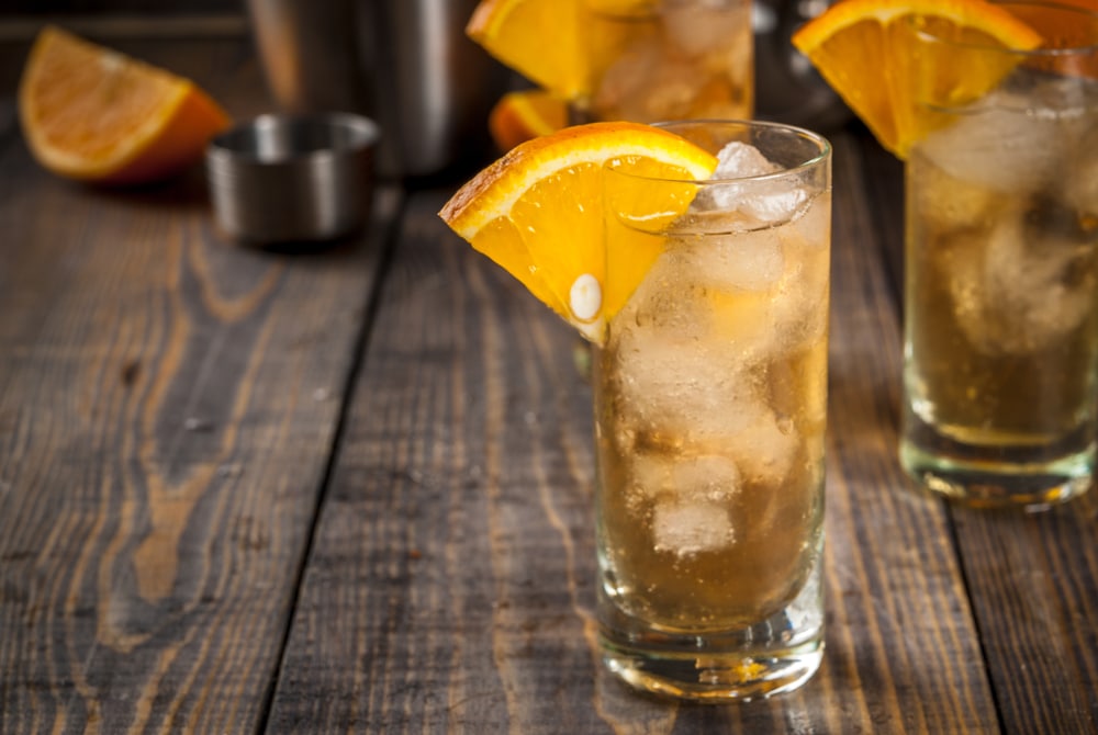 Chilled mocktail drink garnished with an orange slice on wooden table