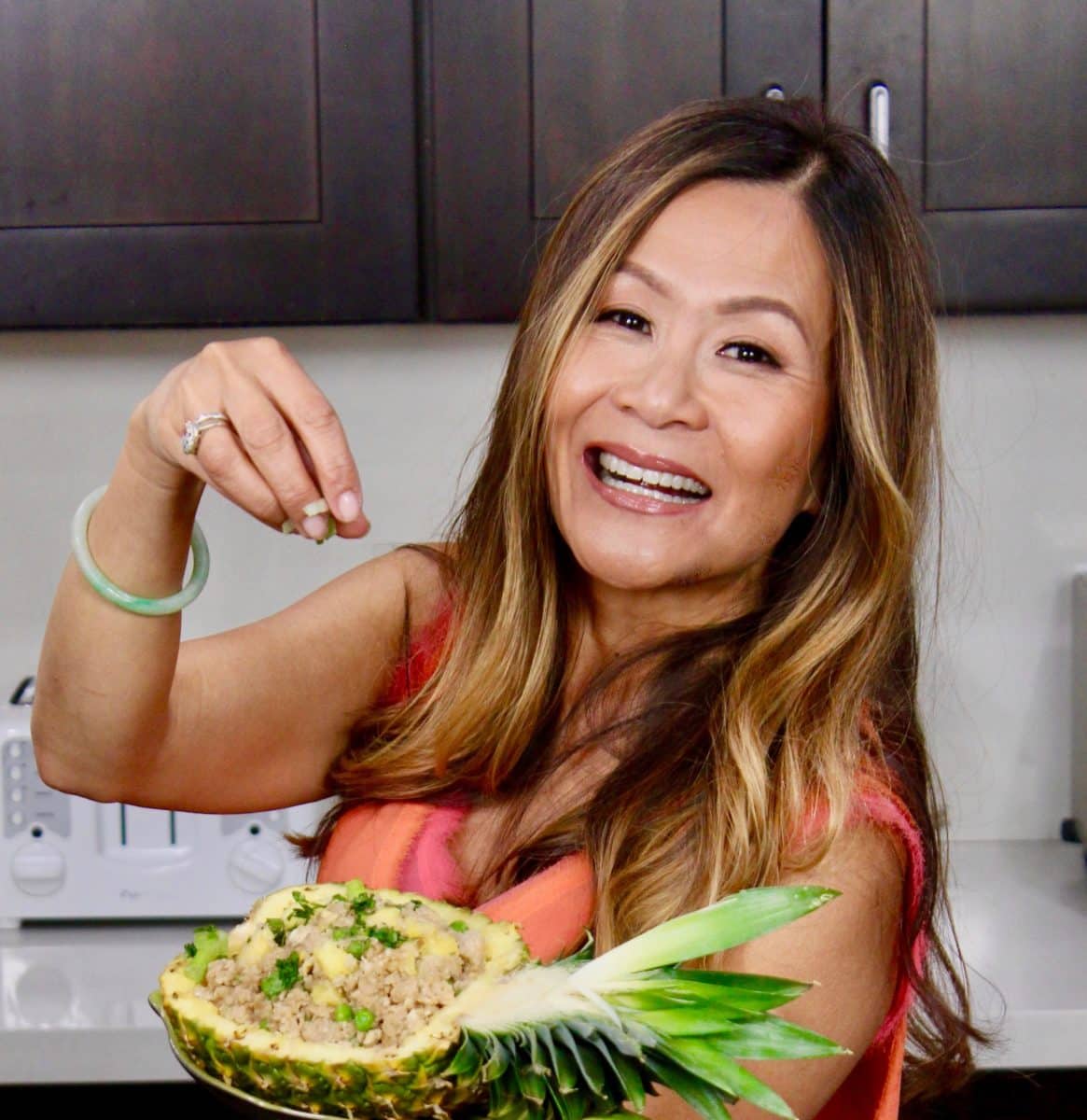 Portrait of Katie Chin smiling in a red top.