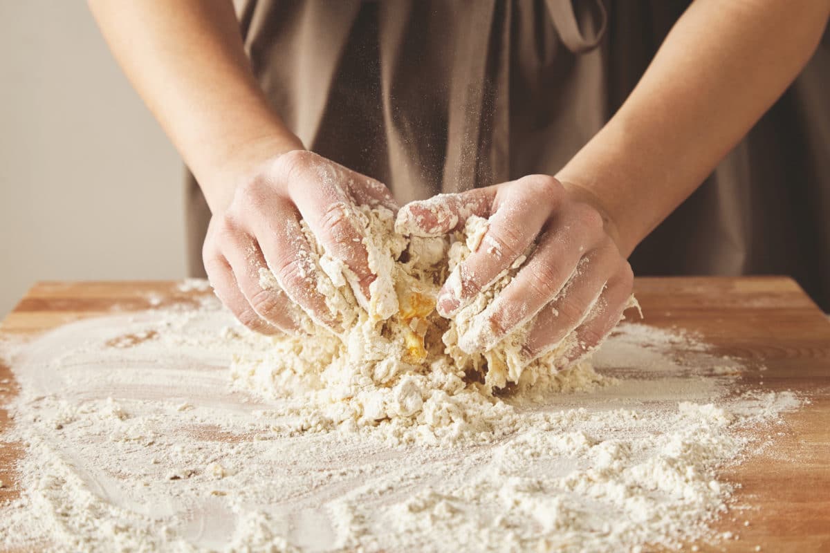 Close-up of a woman's hands as she skillfully kneads dough for pasta.