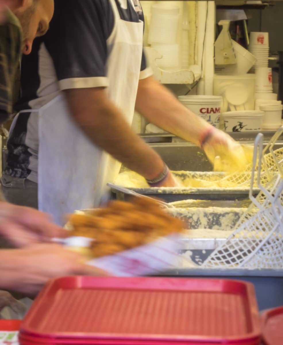 Line cooks working swiftly in a bustling kitchen environment