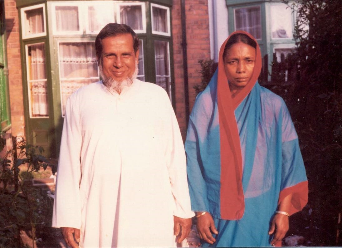 Nana and Nani standing together in their garden after a meal.