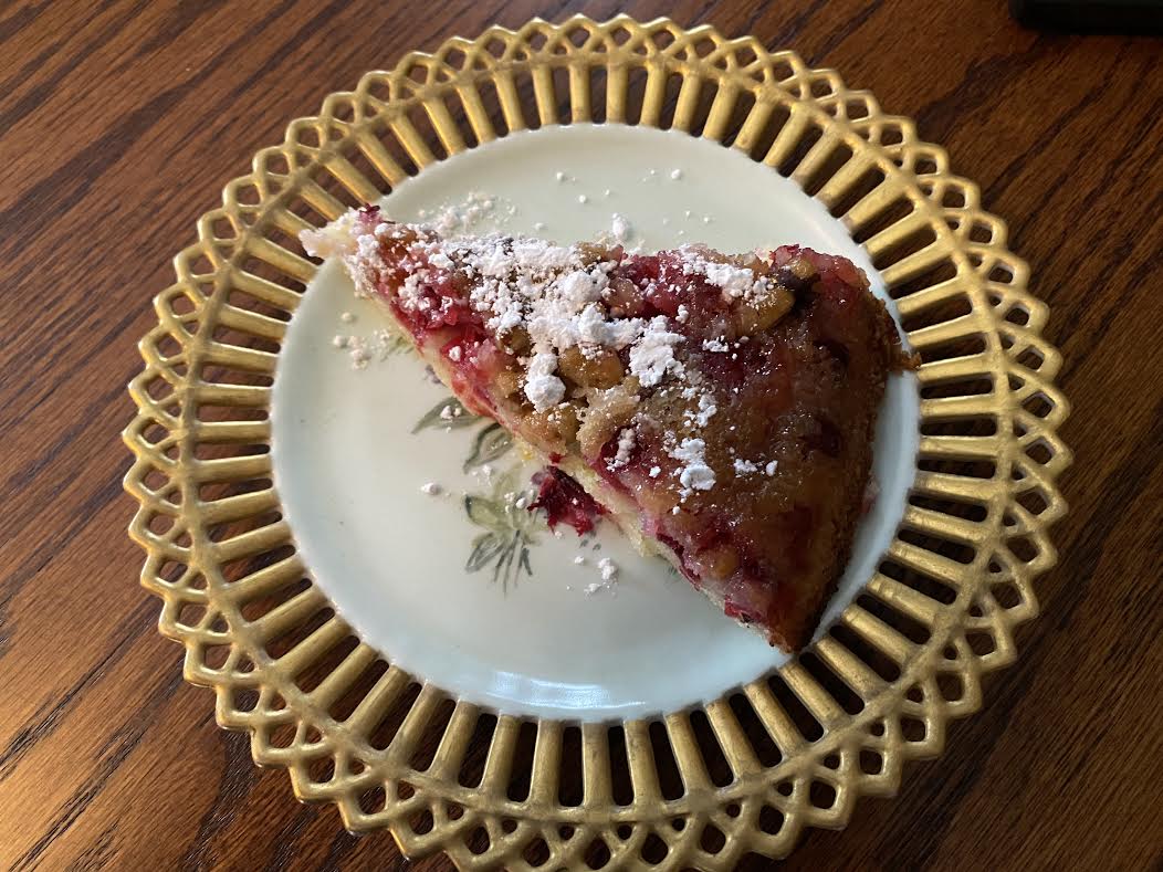 Slice of Nantucket cranberry pie dusted with powdered sugar.