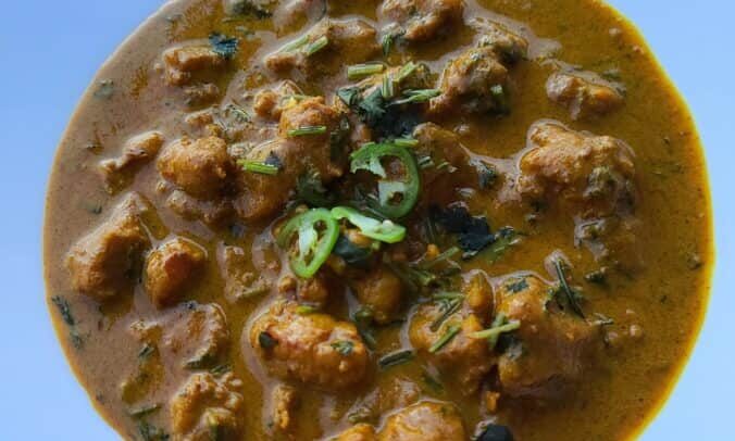 popcorn lobster yellow curry in a blue bowl