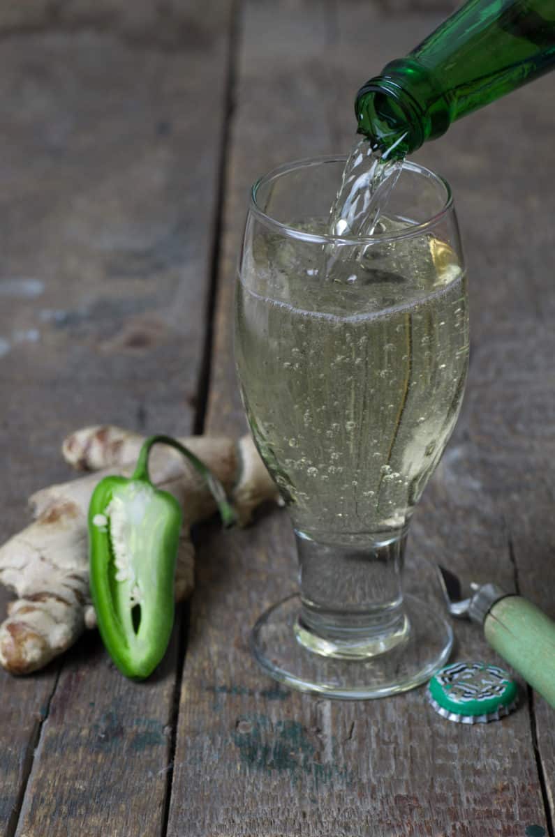 Pouring non-alcoholic ginger beer into a glass.