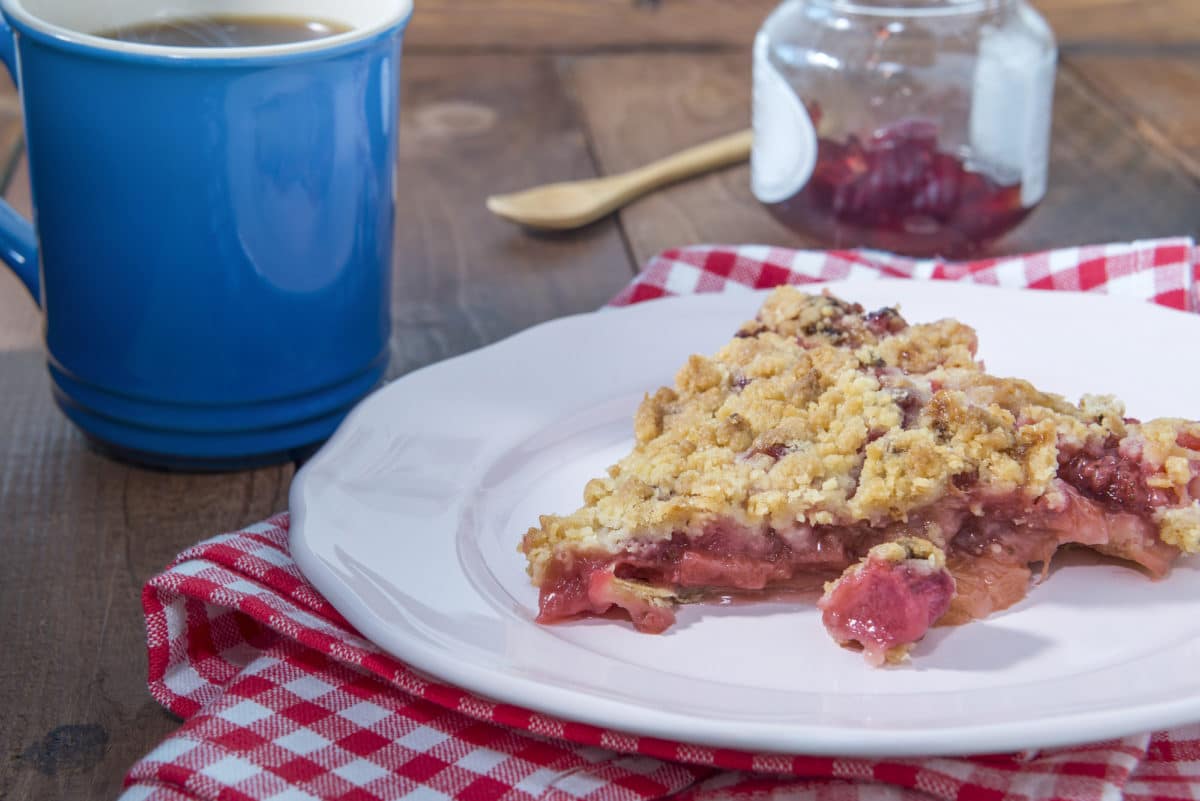 Strawberry rhubarb pie with crumble topping on a plate.