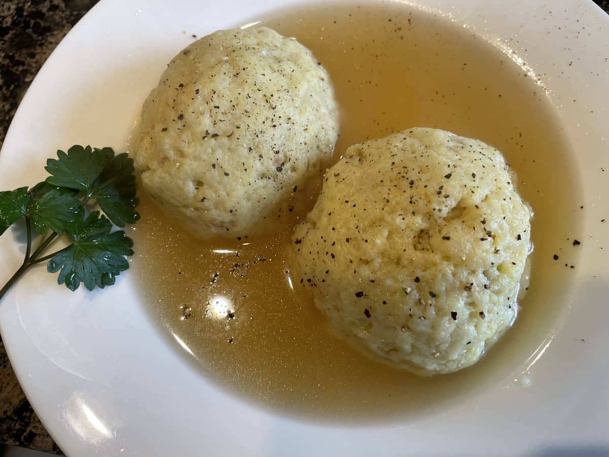 Two matzo balls in clear soup broth