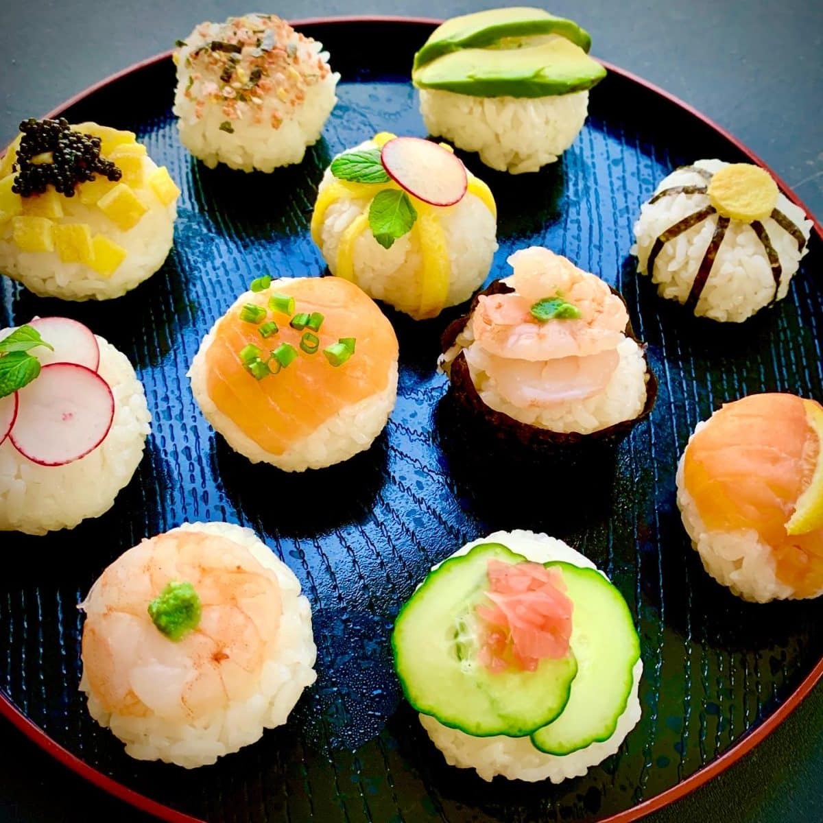 Temarizushi sushi arranged artistically on a blue plate