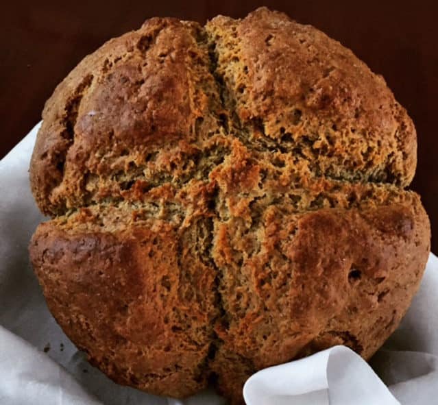 Freshly baked Irish soda bread placed on a white table linen.
