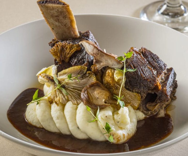 Succulent wine braised short ribs served over mashed potatoes with mushrooms and sauce.