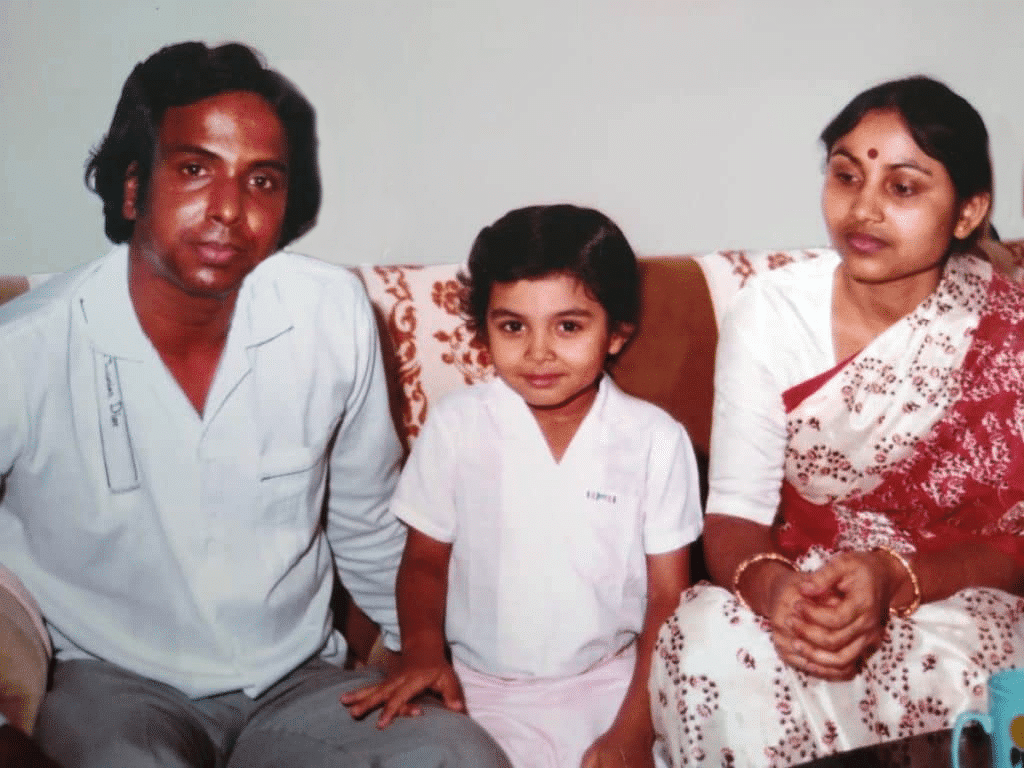 Family of three with a man, young child, and woman in saree