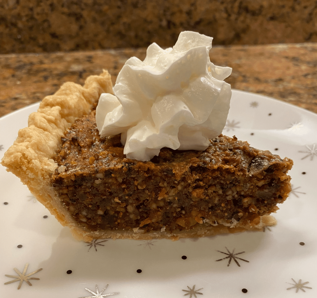 A slice of Neapolitan pie topped with whipped cream.